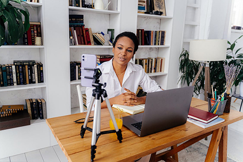 African woman sitting in computer science class. Lady with glasses. Female student sitting at the computer.