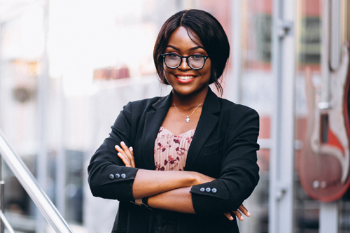 African woman sitting in computer science class. Lady with glasses. Female student sitting at the computer.